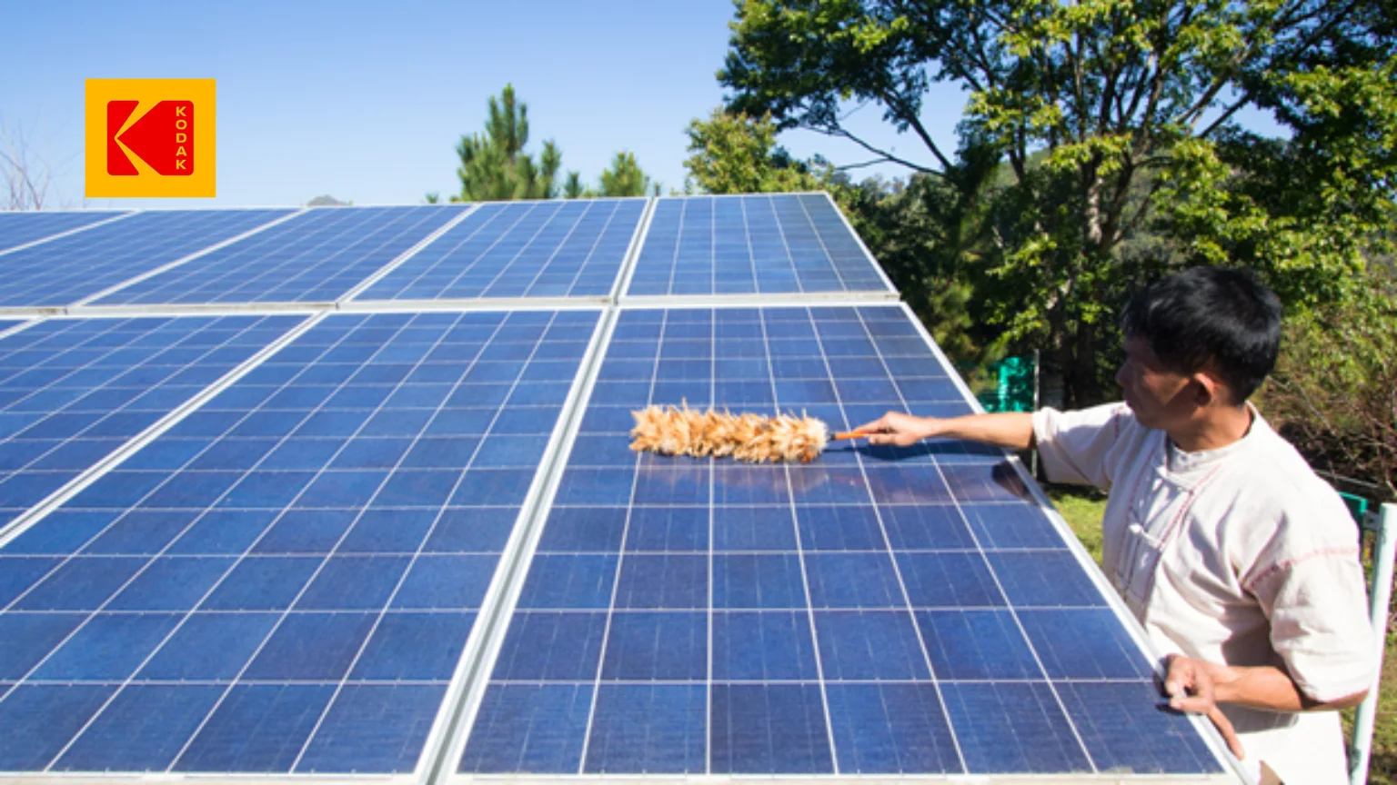 Un homme brossant délicatement un panneau solaire.